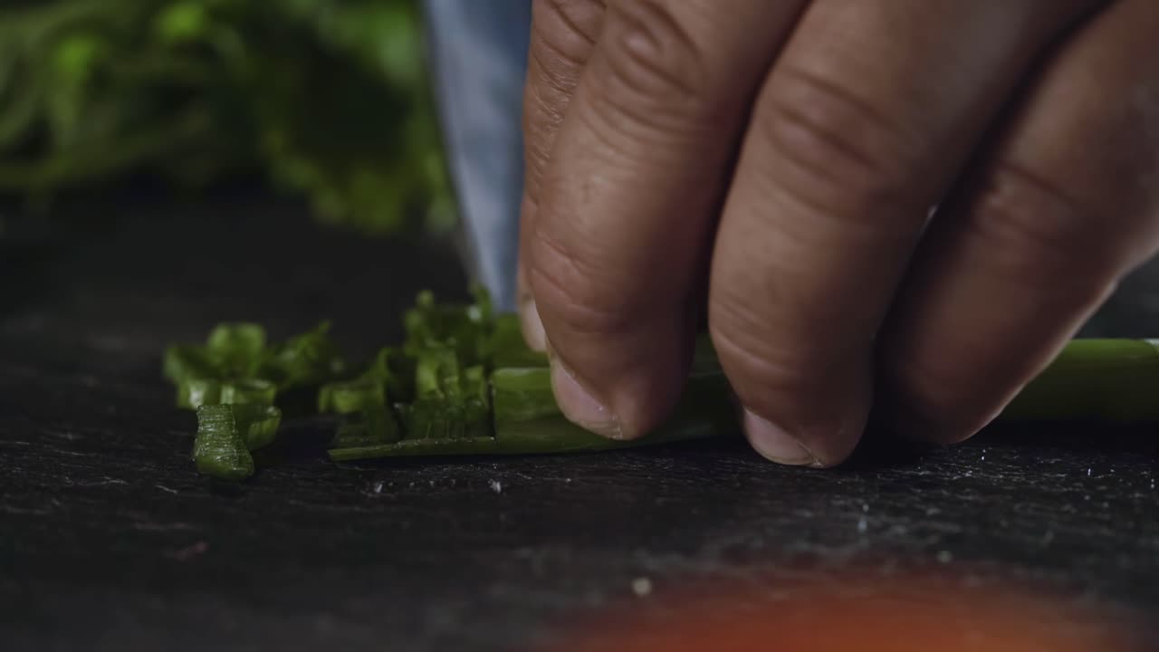 Close-up of Hands Chopping Fresh Green Herbs
