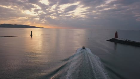tiro de seguimiento aéreo, barco piloto saliendo del puerto al atardecer