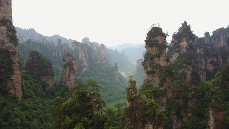 Aerial-flies-between-jagged,-narrow-rock-spires-in-Hunan-China-nature