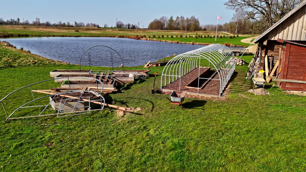 Aerial: farm with a small pond in a rural zone during the day, outdoor, orbit drone shot