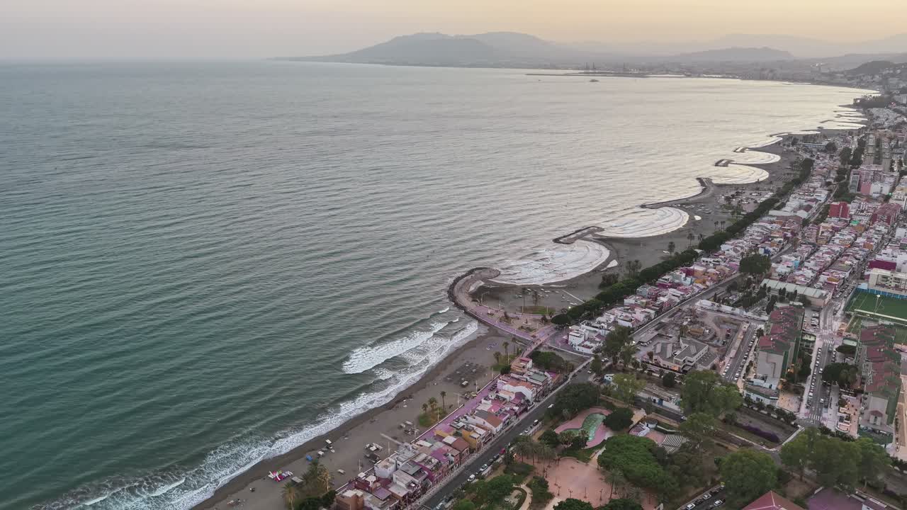 Backward panorama drone fly at El Palo Beach aka Playas del Palo coastal beach beside the calm Alboran Sea, Malaga, Andalusia, Spain