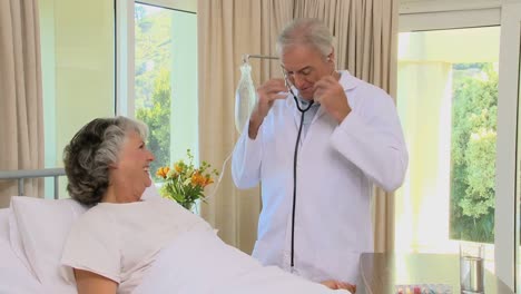 doctor examining blood pressure of a old woman