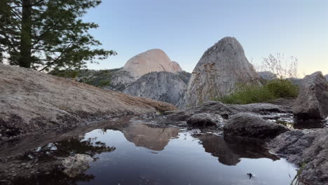 un pequeño manantial en un escarpado paisaje montañoso de granito - estático