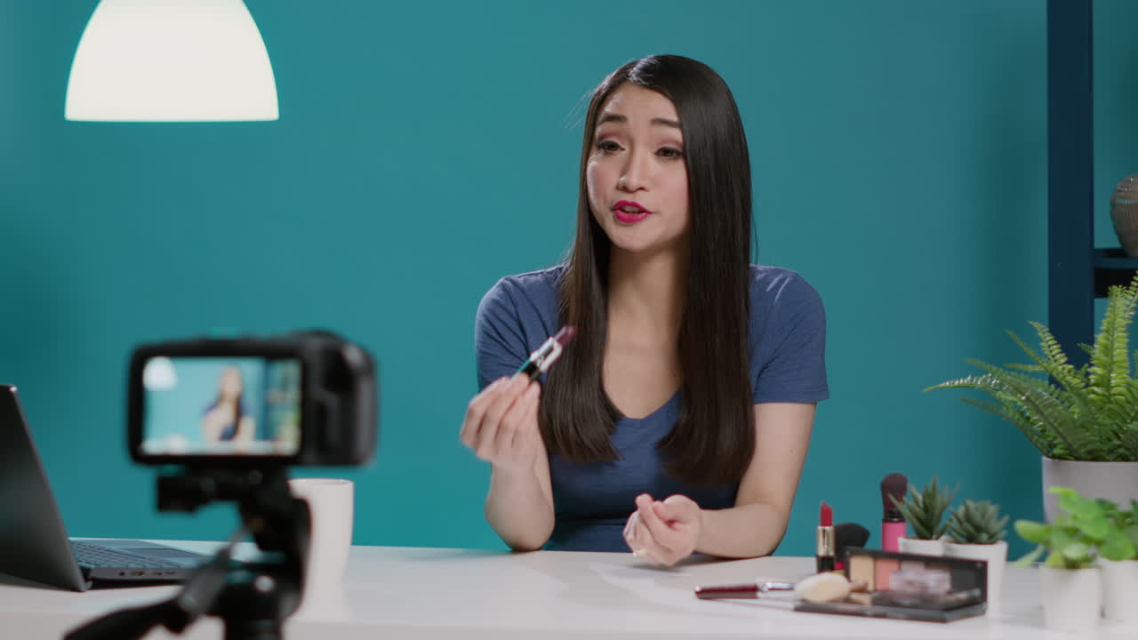 Asian influencer reviewing lipstick product on vlogging camera