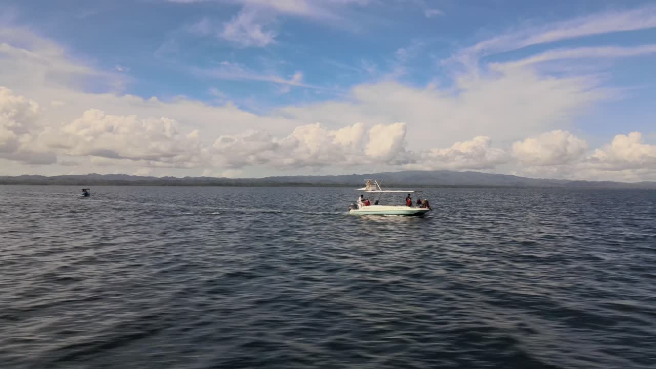 vista lateral de la familia en un barco de pesca navegando a alta velocidad