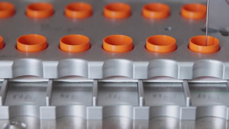 close-up in the medical laboratory, the robot pierces a jar of liquid with a needle and pours it into a tube for further analysis by the doctor