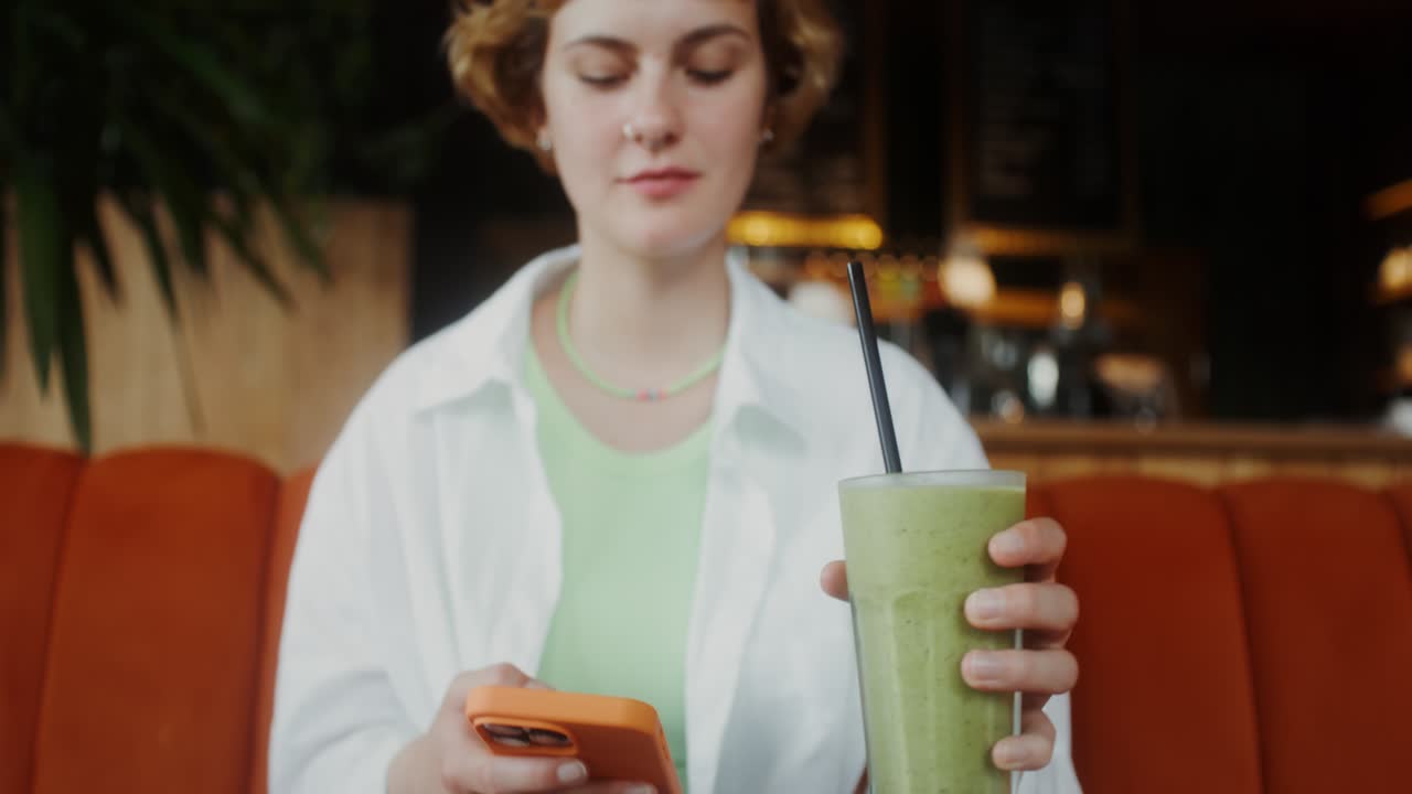 женщина отдыхает и пьет смузи в кафе.