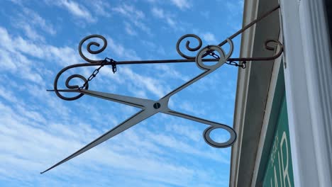 a metal scissor sign outside a hairdresser in suburban cape town, south africa.