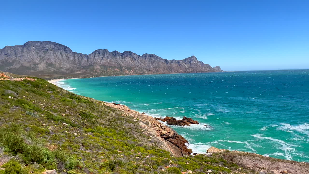 Koeel Bay Dappat Se Gat cinematic windy surf waves crashing stunning Kogel Bay Beach Cape Town South Africa coastline aqua deep blue water Gordon's Bay Garden Route forward pan left
