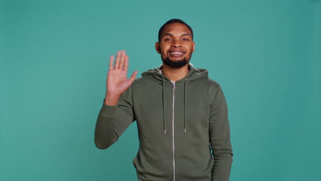 portrait of cheerful man smiling, waving hand