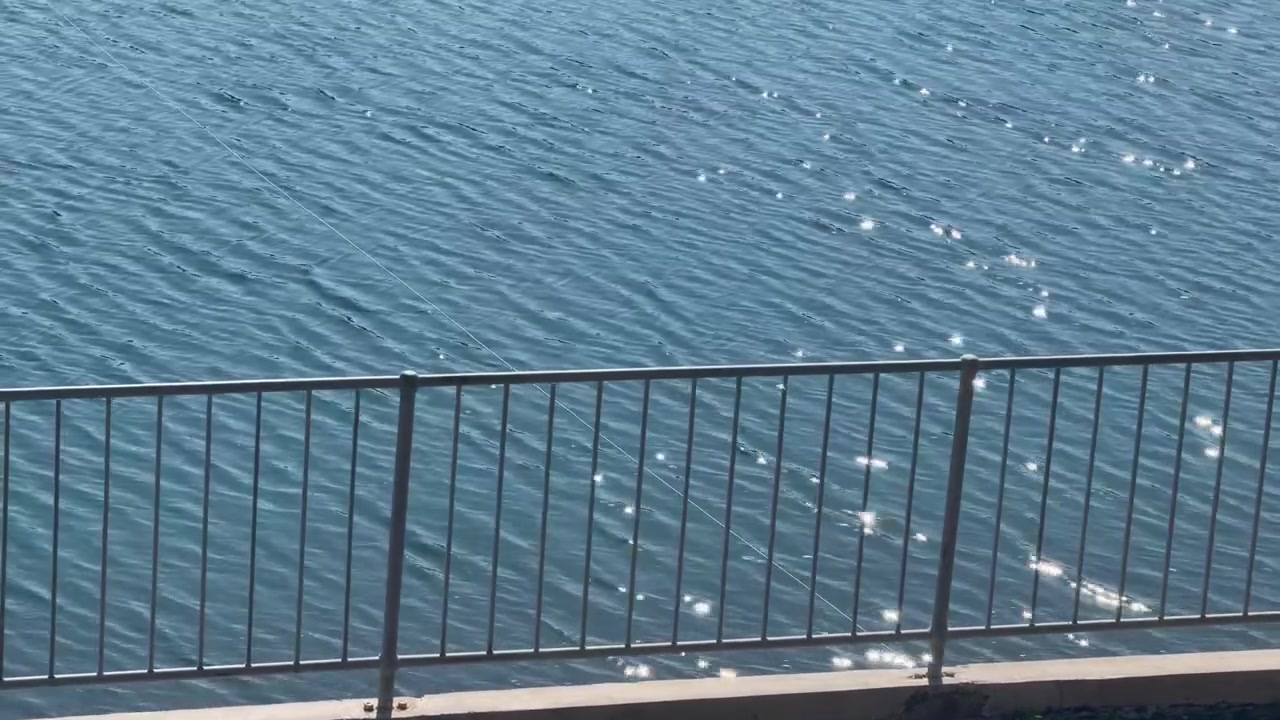 Una valla y la superficie de un lago.