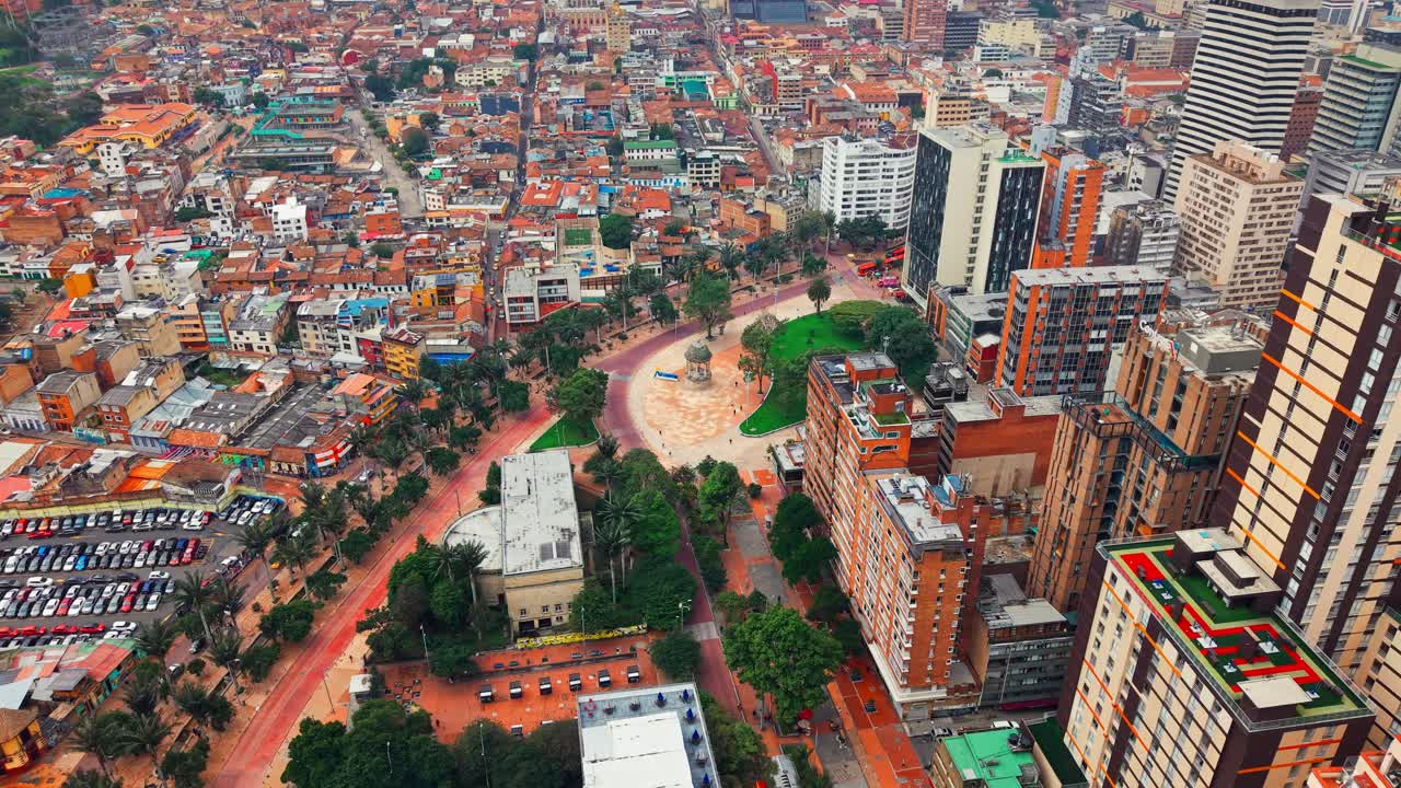 Aerial orbit establishing the contrast of the city of Bogota, Colombia at the Gabriel García Marquez journalists' square, on a sunny day, La Candelaria neighborhood.