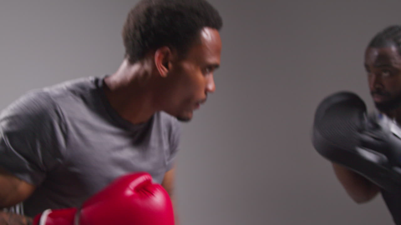 Real Time Studio Shot Of Male Boxer Sparring Working Out With Trainer Wearing Punch Mitts Or Gloves Practising For Fight 2