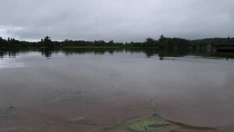 Low-Angle-Shot-of-Lake-on-Stormy-Overcast-Day-in-Ontario-Canada---Heavy-Clouds-Over-Calm-Waters