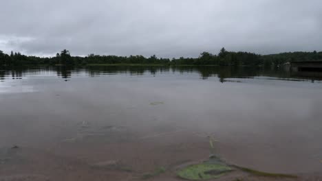 low angle shot of lake on stormy overcast day in ontario canada - heavy clouds over calm waters