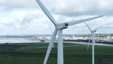 alternative green energy wind farm turbines spinning in frodsham cheshire fields aerial view closeup orbit left