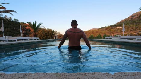 man entering an infinity pool