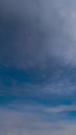 soft light clouds quickly flowing by the horizon. heavy grey clouds changing soft ones. low angle view. timelapse. vertical video