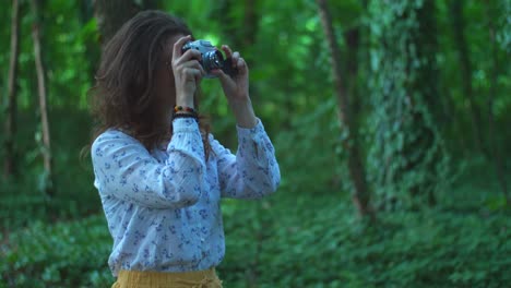 a young woman making pictures outdoors with an old film camera