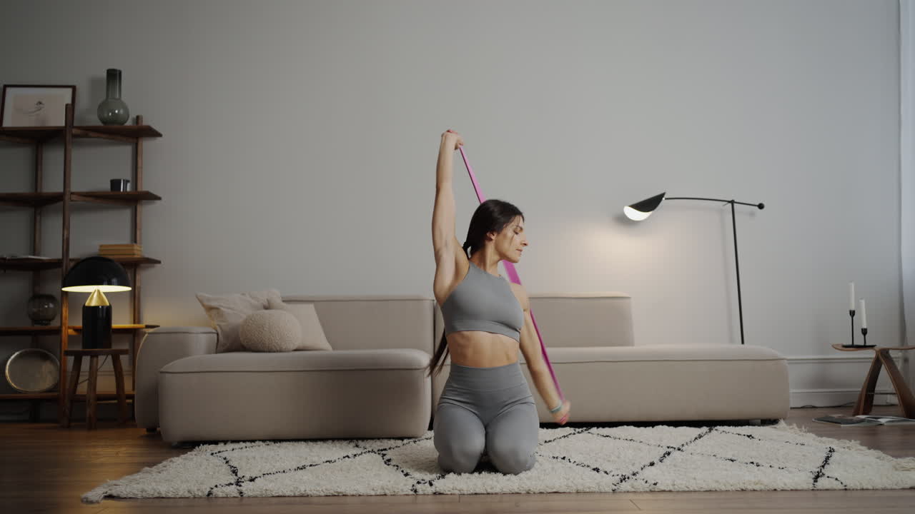 mujer haciendo ejercicios de brazo de banda de resistencia en casa