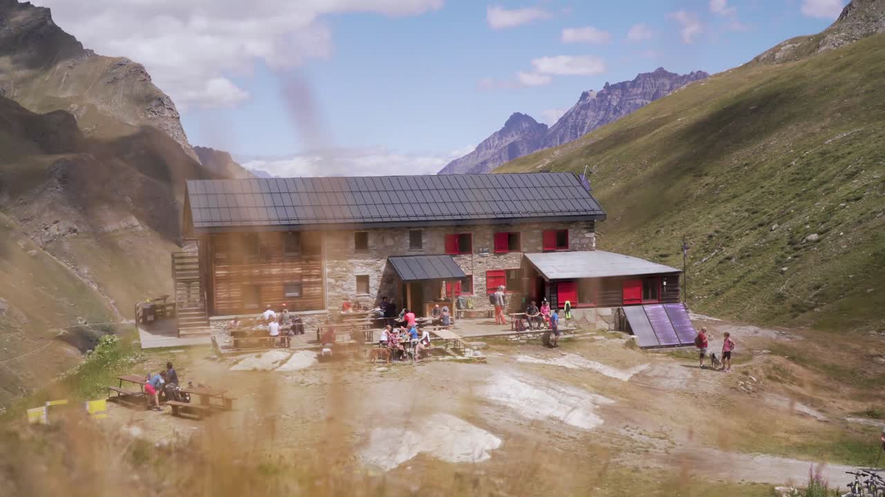 Lavvinkeloptagelse af en bjerghytte af træ og sten i de østrigske Alper.