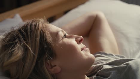 caucasian woman enjoying the sunlight in morning in the bed.