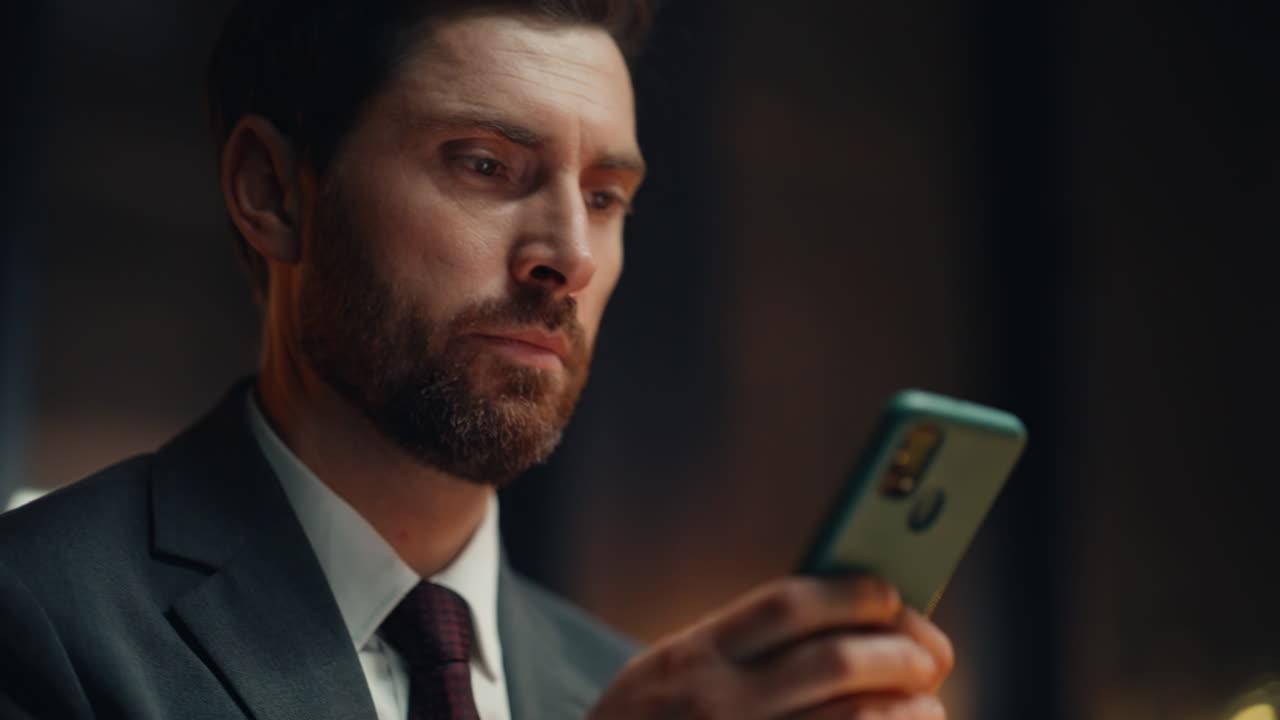 Manager hand texting cellphone screen answering email at night office closeup