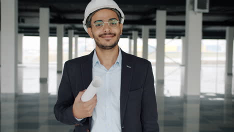 architect reviewing blueprints in an empty building