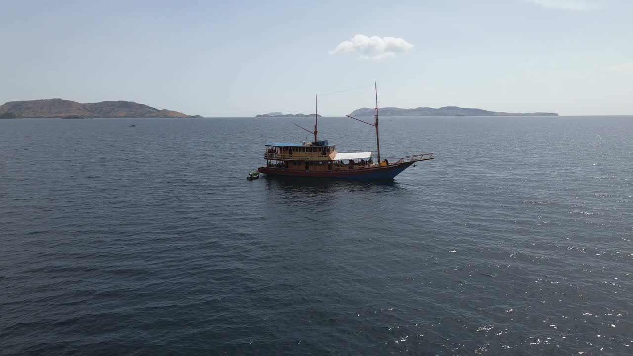 Wooden Passenger Boat Cruising In The Ocean In Bali, Indonesia. - aerial orbit