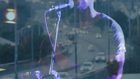 bandmates playing drums and singing into microphone in music studio, overlaying highway lights
