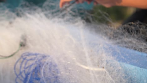 hands removing stick from fishing net