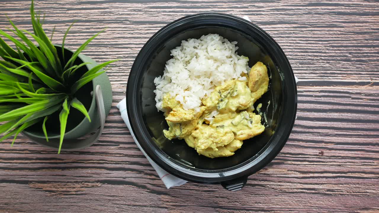 curry de pollo con arroz en un recipiente negro