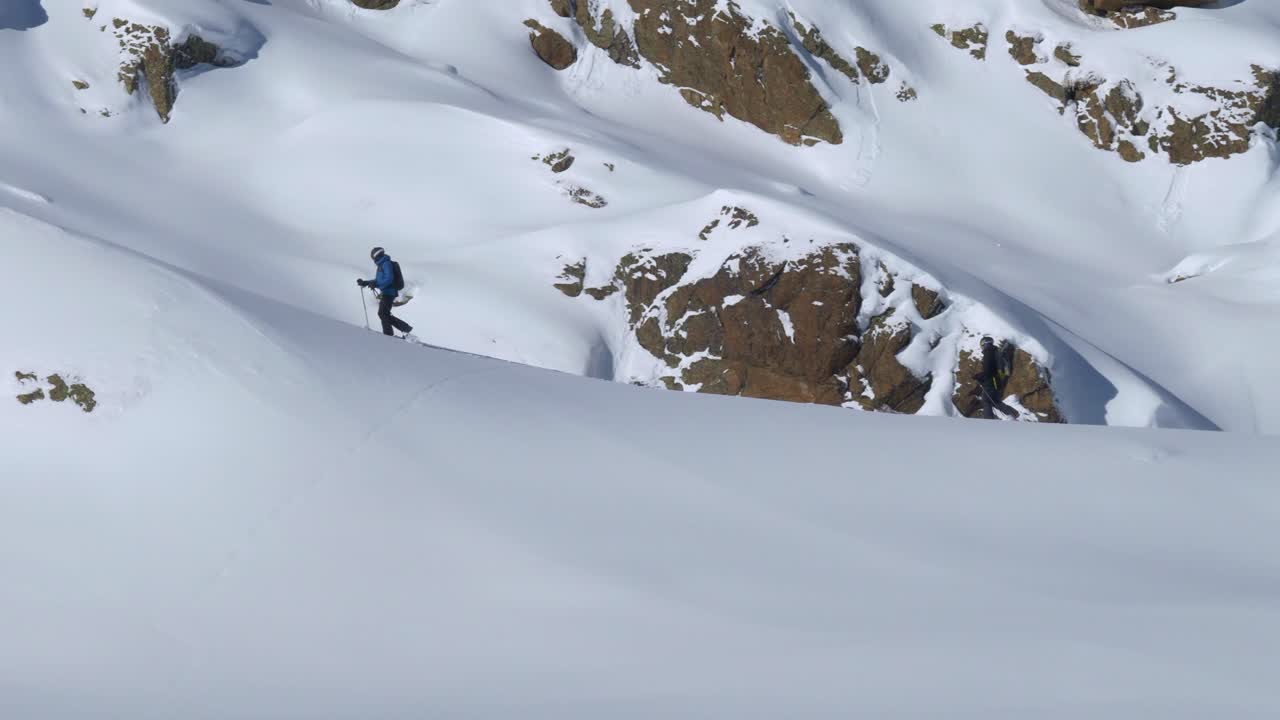 free-riders caminando en nieve profunda en una montaña rocosa, día de invierno en los alpes - vista panorámica