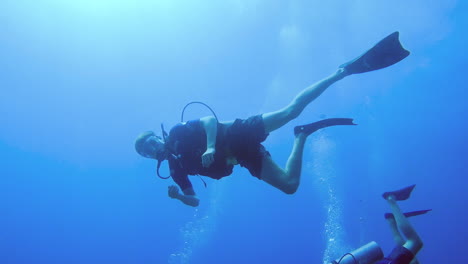 buzo mostrando los pulgares hacia la cámara en el océano azul
