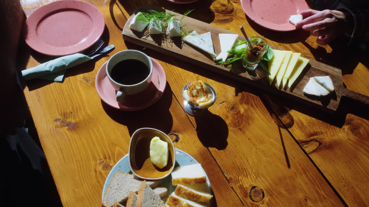 치즈 조각을 뽑기 위해 손으로 음식으로 가득 찬 테이블의 오버헤드  ⁇ , 중간  ⁇