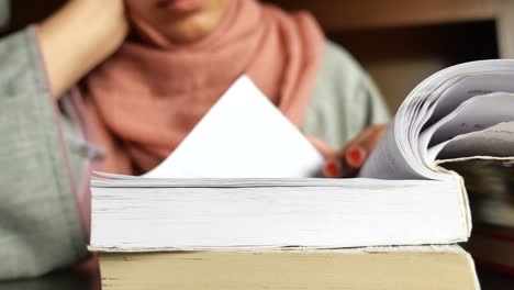 woman wearing hijab reading a book