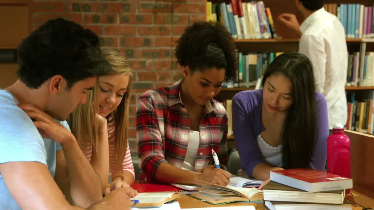 compañeros de clase sonrientes estudiando en la biblioteca
