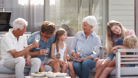 multi generation family enjoy outdoor drinks and snacks at home