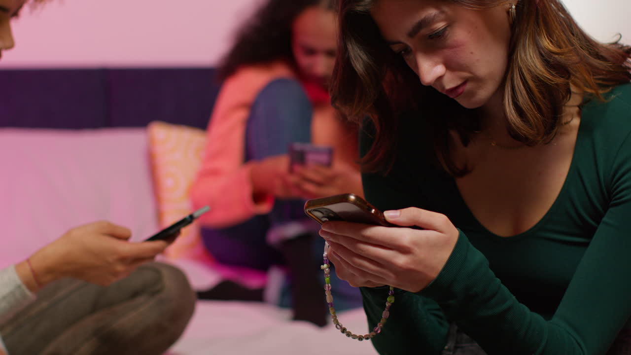 amigos usando teléfonos inteligentes en un dormitorio