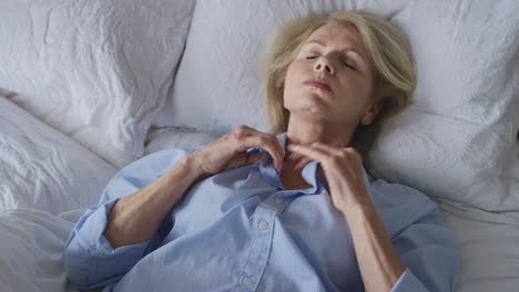 Menopausal Mature Woman Suffering With Insomnia In Bed At Home
