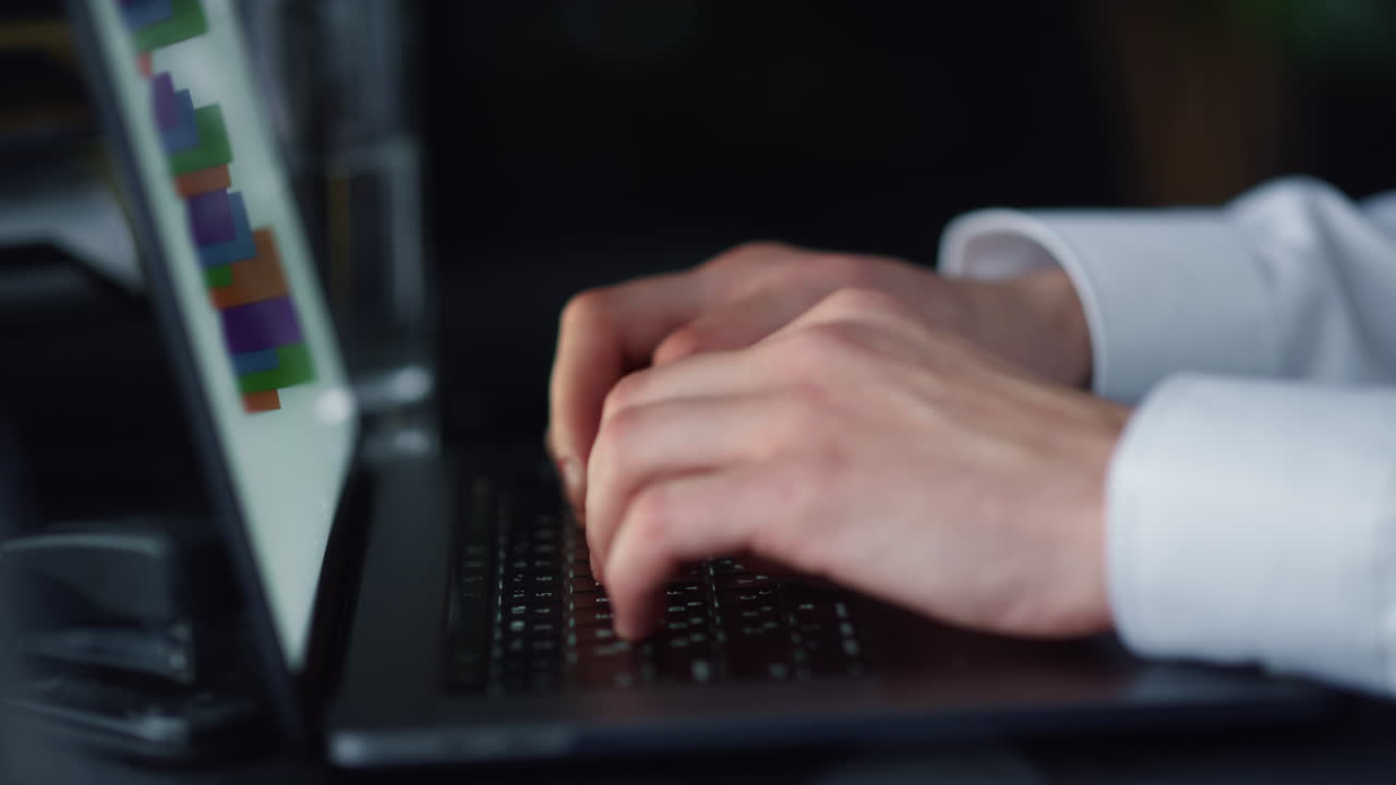 Businessman typing on laptop keyboard in office. Person pushing keys on keyboard