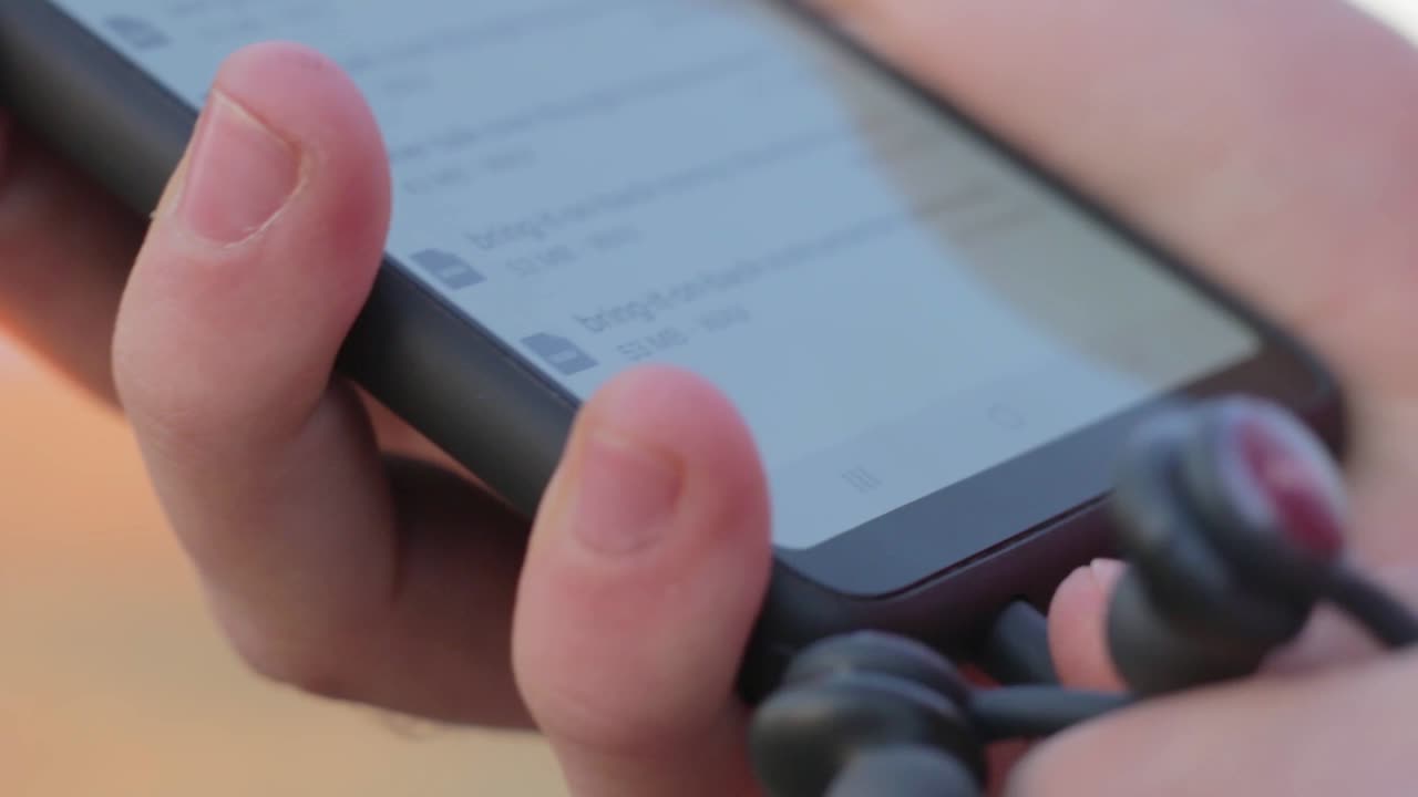 hombre conectando auriculares al teléfono para escuchar