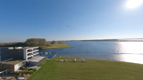 FPV-drone-tracking-shot-following-an-eagle-in-a-semi-rural-area-on-a-cloudless-day