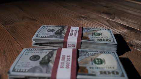 three stacks of 10000 american dollars banknotes in bundles lie on wooden table