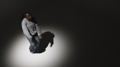 Looking-Down-On-Studio-Shot-Of-Young-Woman-Dancing-In-Spotlight-In-Slow-Motion