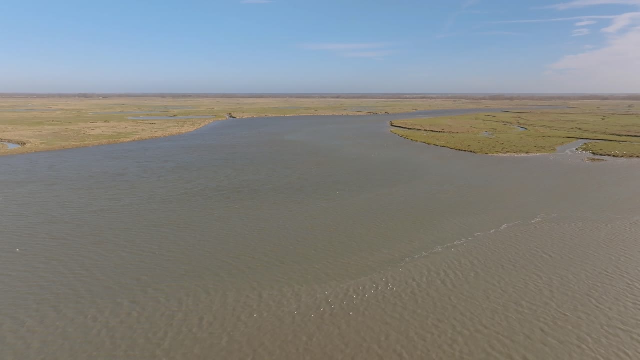 Ripresa aerea ad alta quota che domina le vaste paludi salmastre e gli intricati canali della riserva naturale della Baia della Somme
