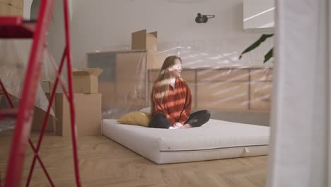 woman relaxing on a mattress during apartment renovation