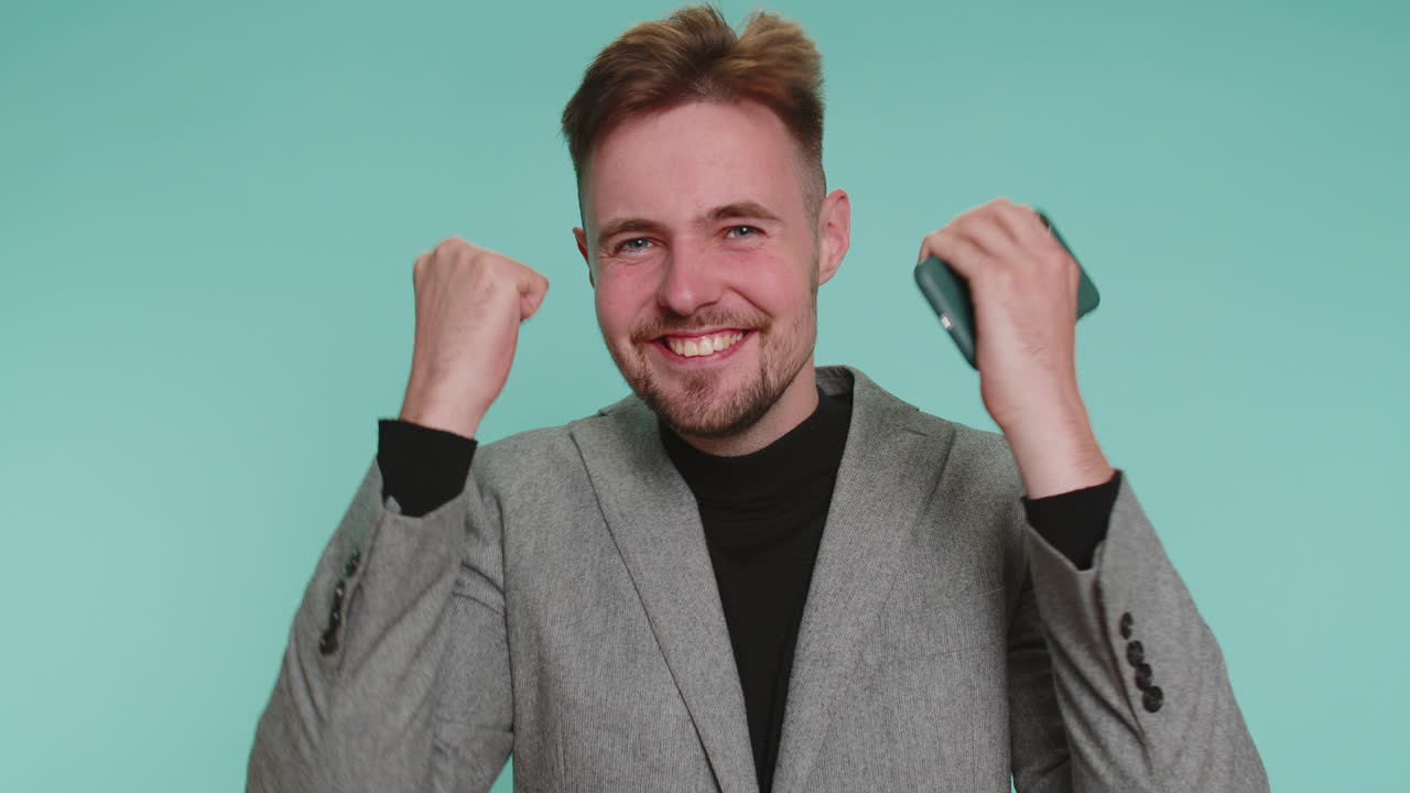 glücklicher geschäftsmann nutzt mobiltelefon sagen wow ja herausgefunden große große gewinn neuigkeiten tun gewinner geste