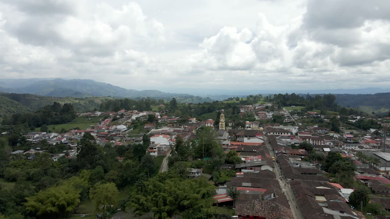 Low aerial view of Salento green hills and city buildings, urban beauty in Colombia