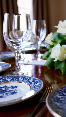 elegant formal dining table setting with blue and white china and white roses